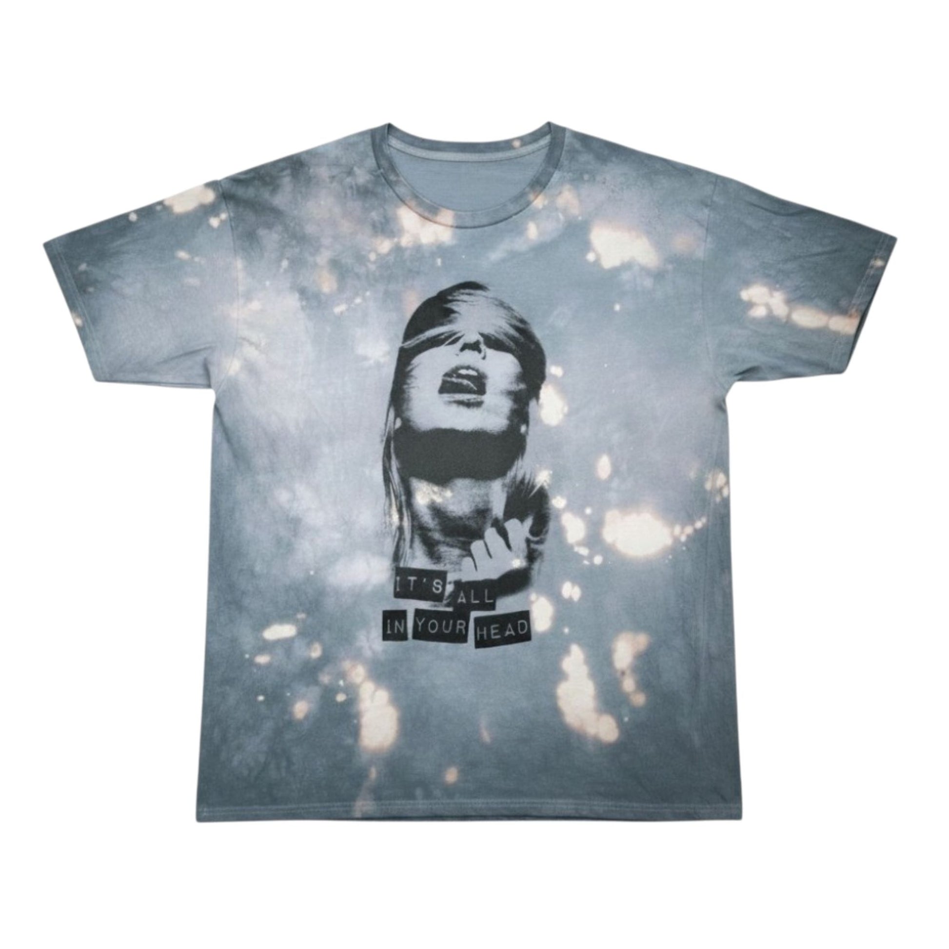 A short-sleeve crewneck t-shirt featuring a blue-gray and white tie-dye pattern with a central graphic of a blindfolded woman's face and the text 'IT'S ALL IN YOUR HEAD'.