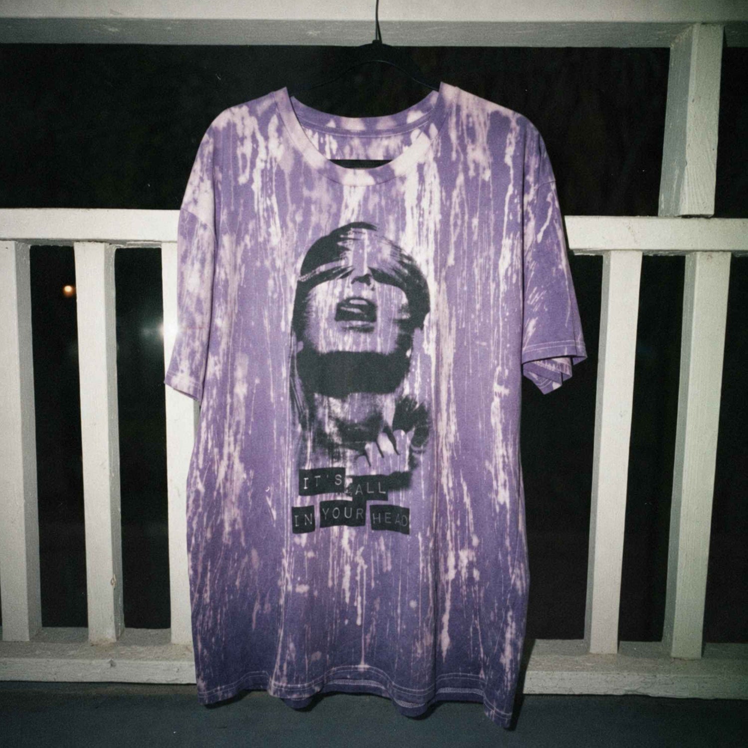All in Your Head 1/1 hand-bleached and hand-dyed purple short sleeve tee hanging outdoors at night