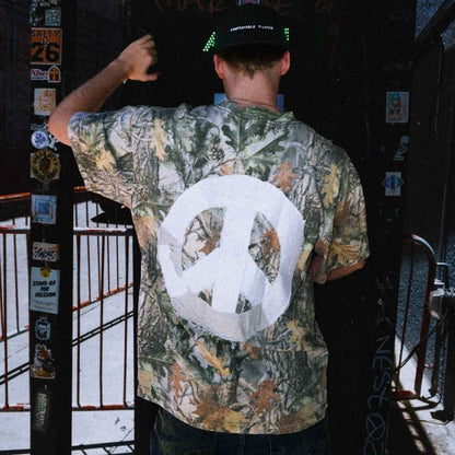 Back view of DG Gamble x Comfortable Silence one-of-one camouflage t-shirt featuring hand-sewn patchwork peace sign