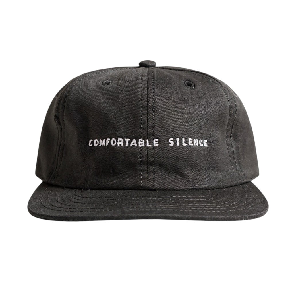 Black cap with 'Comfortable Silence' text on a white background