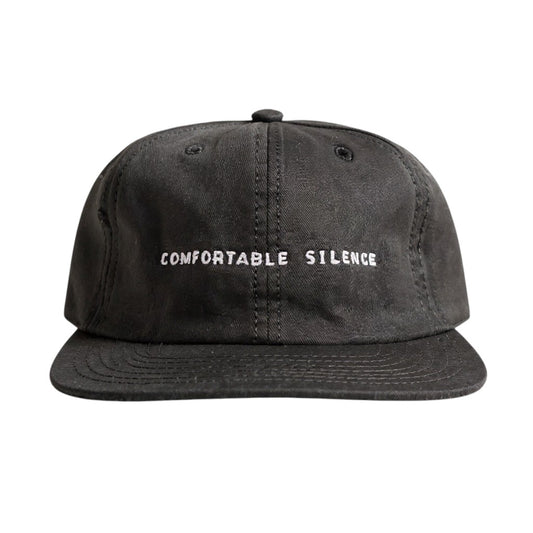 Black cap with 'Comfortable Silence' text on a white background