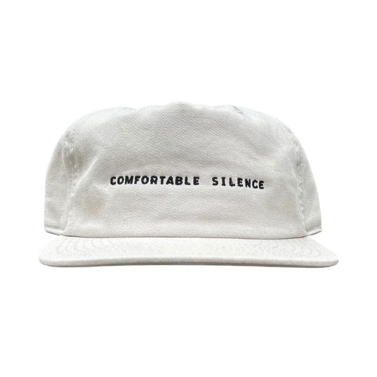 Bone colored cap with 'Comfortable Silence' text on a white background