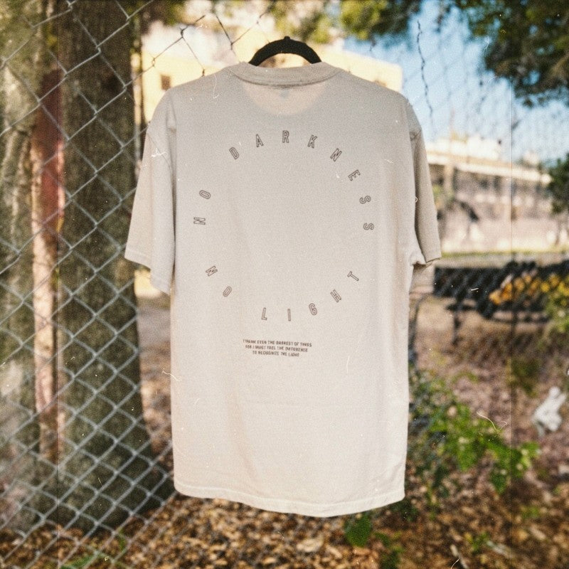 Circular "No Darkness No Light" typography on faded bone heavyweight streetwear shirt.