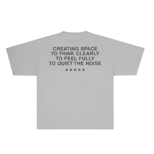 Vintage grey tshirt with text "creating space to think clearly, to feel fully, to quiet the noise" on a white background 