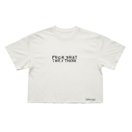 An off-white cropped t-shirt with the text 'FUCK WHAT THEY THINK' printed in black across the chest, displayed flat against a white background.