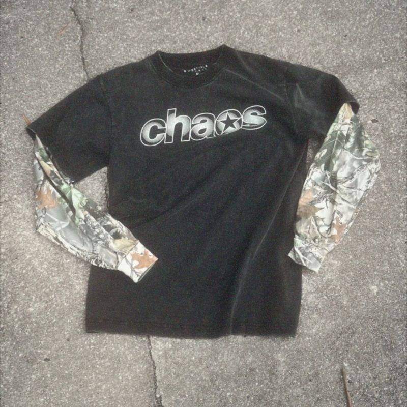 Black t-shirt with 'chaos' design and camouflage sleeves on a concrete surface